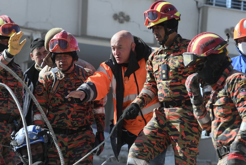 Arif Akdag (tengah) membantu Komander STORM Ismail Abdul Ghani (dua dari kanan) dan Ketua Balai Bomba dan Penyelamat Presint 7, Putrajaya, Mohd Yaacob Yusoff (dua dari kiri) ketika melakukan operasi mencari dan menyelamat di kawasan runtuhan baru-baru ini di Nurdagi. - Foto Bernama
