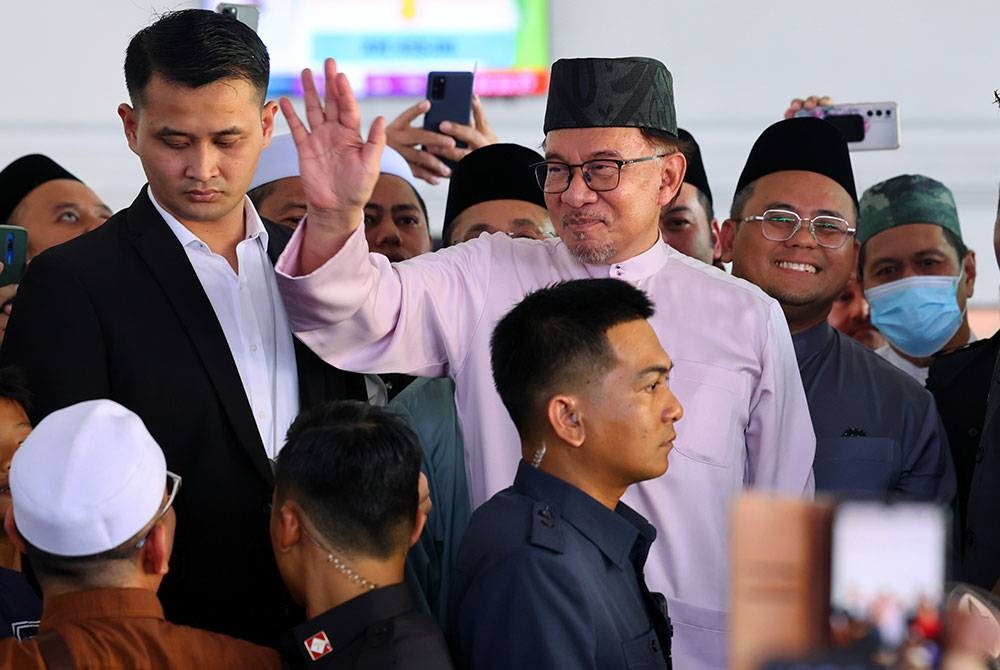 Perdana Menteri Datuk Seri Anwar Ibrahim (trengah) melambaikan tangan ke arah jemaah di Masjid Taman Putra Perdana selepas menunaikan solat Jumaat hari ini. - Foto Bernama