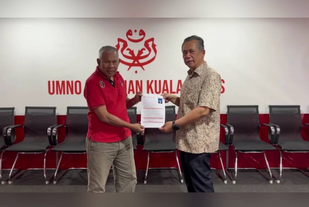 Ahmad Razif (kanan) menyerahkan borang pencalonan kepada Setiausaha Kerja UMNO Bahagian Kuala Nerus, Abu Bakar Jusoh di pejabat parti itu di Batu Enam pada Sabtu.