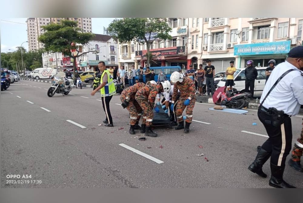 Anggota bomba mengangkat mayat mangsa yang maut dalam kemalangan di Jalan Persiaran Tanjung Tampoi pada Ahad.