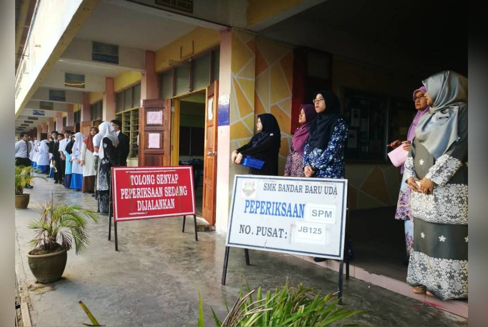 Calon-calon SPM SMK Bandar Baru Uda menunggu giliran masuk ke dewan peperiksaan pada Isnin.