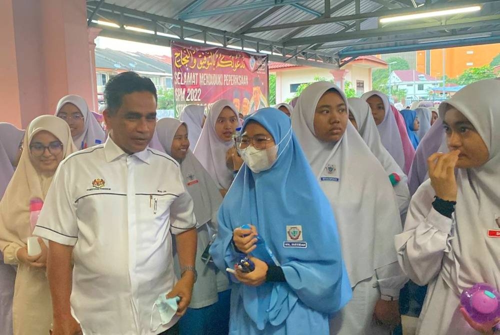 Mohd Zin (kiri) meluangkan masa membuat tinjauan di SMKA Naim Lilbanat, Kota Bharu sempena hari pertama peperiksaan SPM 2022.