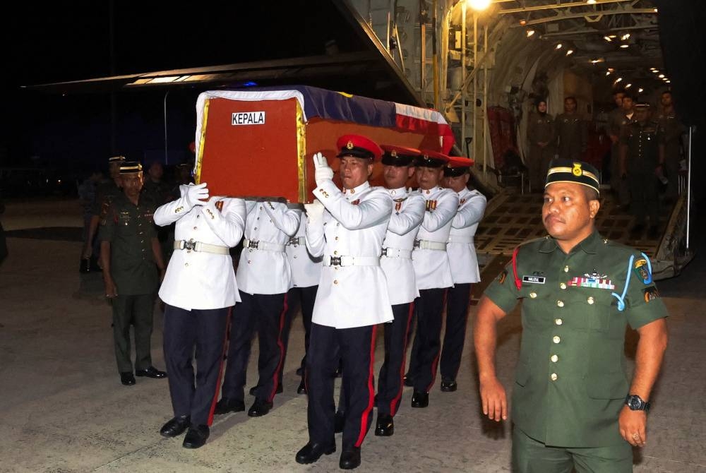 Keranda yang membawa Lans Koperal Edrin Baintim, 25, tiba di Lapangan Terbang Sandakan dengan penerbangan C130 Hercules malam ini. - Foto Bernama