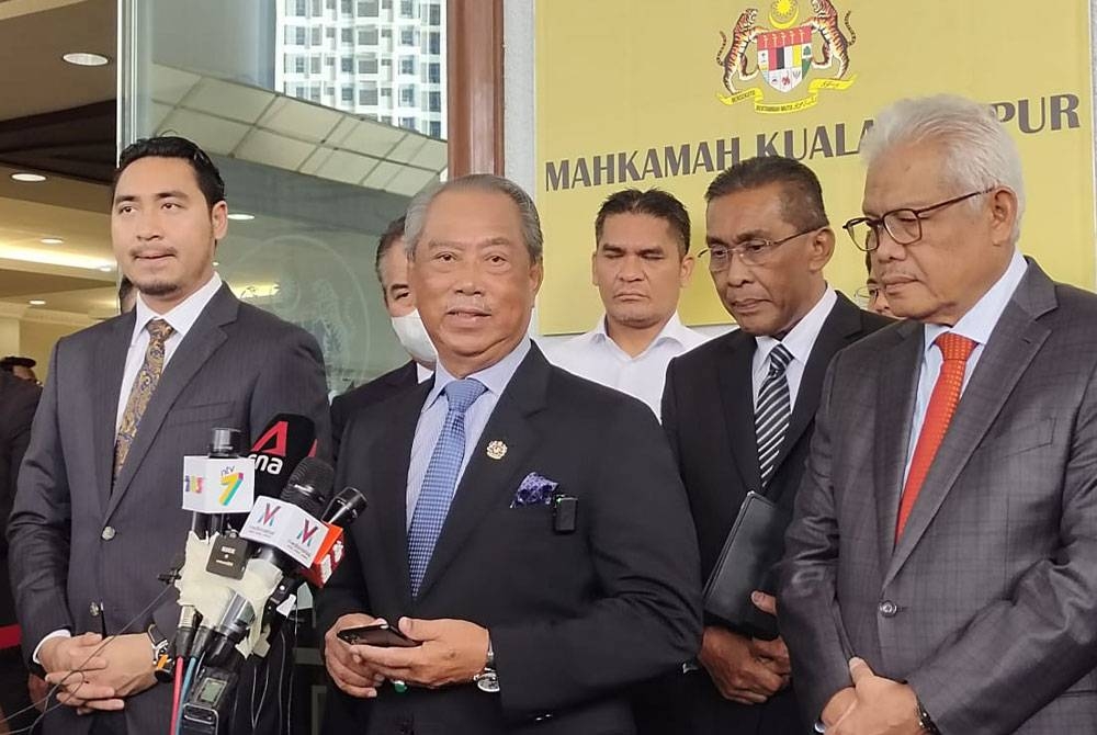 Muhyiddin (tengah) pada sidang akhbar di pekarangan Mahkamah Sesyen, di Kuala Lumpur pada Selasa.