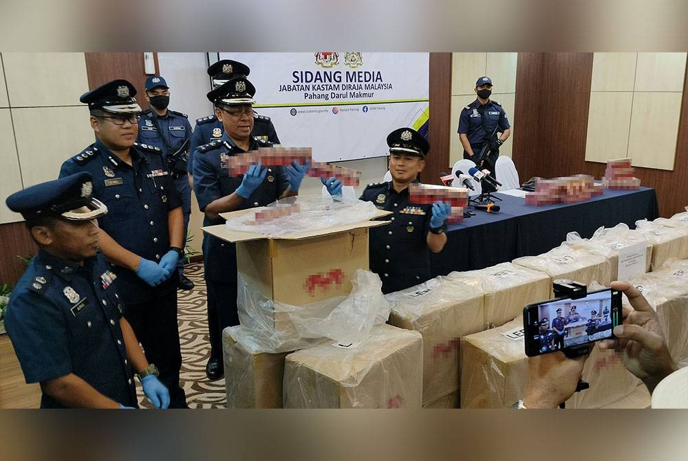 Wan Apandi bersama pegawai Bahagian Penguatkuasaan JKDM Pahang menunjukkan sebahagian rokok yang dirampas.