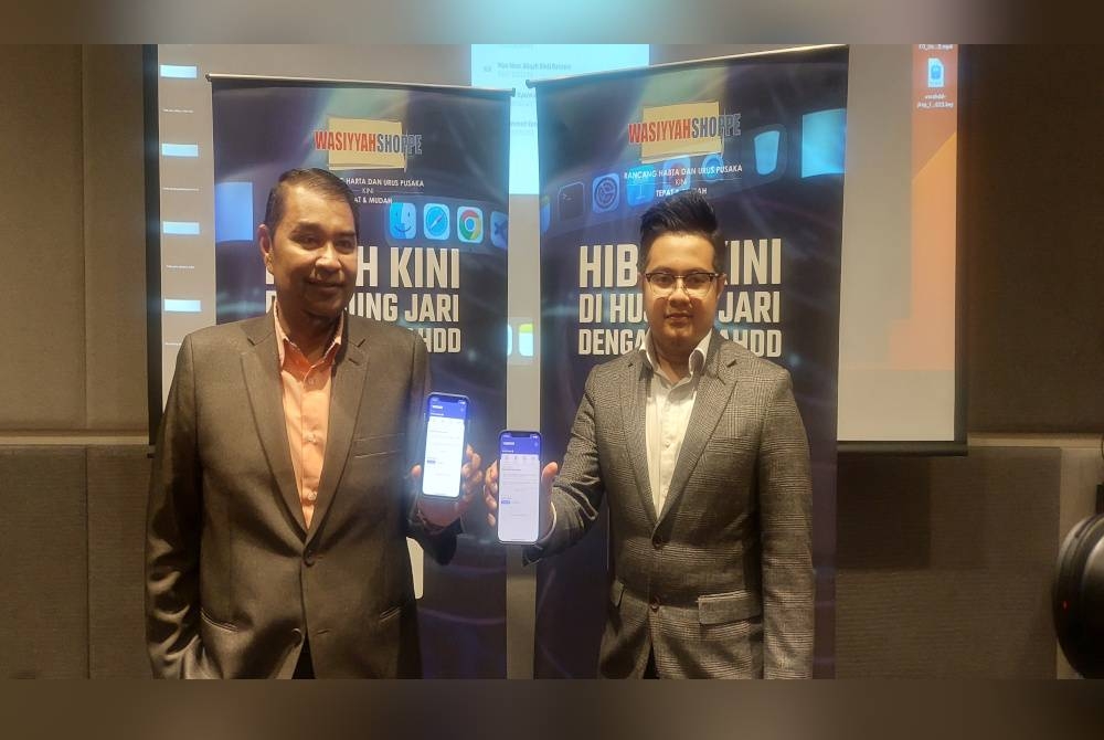 Ariffin (kiri) dan Ketua Pegawai Teknologi syarikat Himayah Technology Sdn Bhd, Omar Mokhtar Kassim menunjukkan aplikasi UsraHDD.