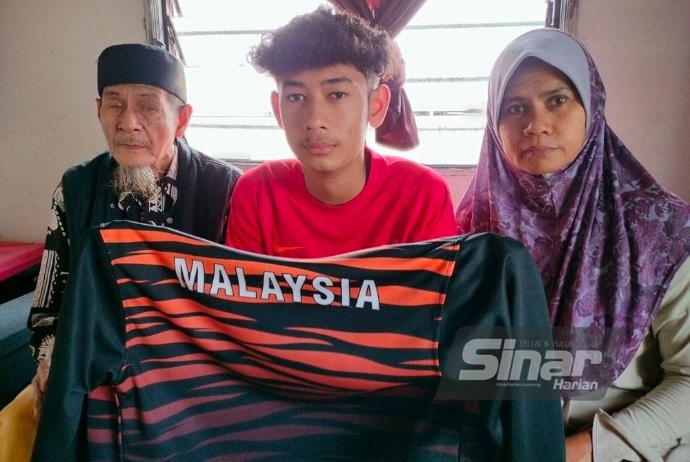 Senin( kiri) bersama Muhammad Amar (tengah) bersama ibunya, Fuziah tidak menyangka anak mereka itu terpilih mewakili Malaysia dalam pertandingan Futsal di Iran April depan ketika ditemui di rumahnya di Kampung Selamat pada Rabu.