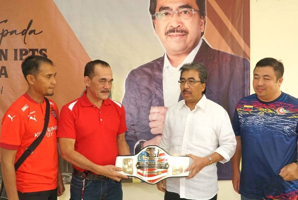 Johari (dua dari kanan) dan Presiden Kelab Muay Thai Kuda Merah, Rosli Yaacob (dua dari kiri) memegang Tali Pinggang Johari Ghani yang menjadi rebutan pada Kejohanan Kuda Merah Muay Thai Antarabangsa 2023.