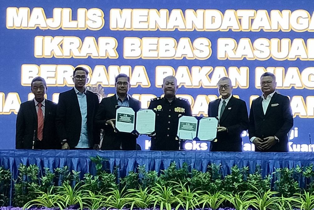 Hamdan (tiga dari kiri) menyerahkan ikrar bebas rasuah yang ditandatangani kepada Ab Muneim (tiga dari kanan) pada Majlis
Menandatangani IBR Bersama Rakan Niaga di dewan Kompleks MBK pada Khamis.