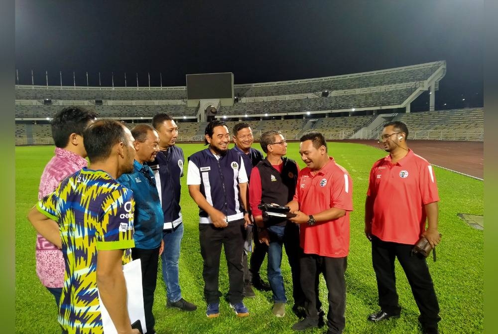 Khairul Anuar (tiga dari kiri) bersama pegawai Perak FC dan Malaysia Super League (MSL) memeriksa tahap kecerahan Stadium Perak di Ipoh pada malam Khamis.