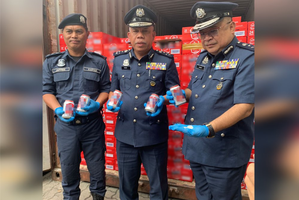 Mohd Nasir (tengah) menunjukkan minuman keras yang cuba diseludup masuk ke negeri ini melalui Pelabuhan Sepanggar Kota Kinabalu.