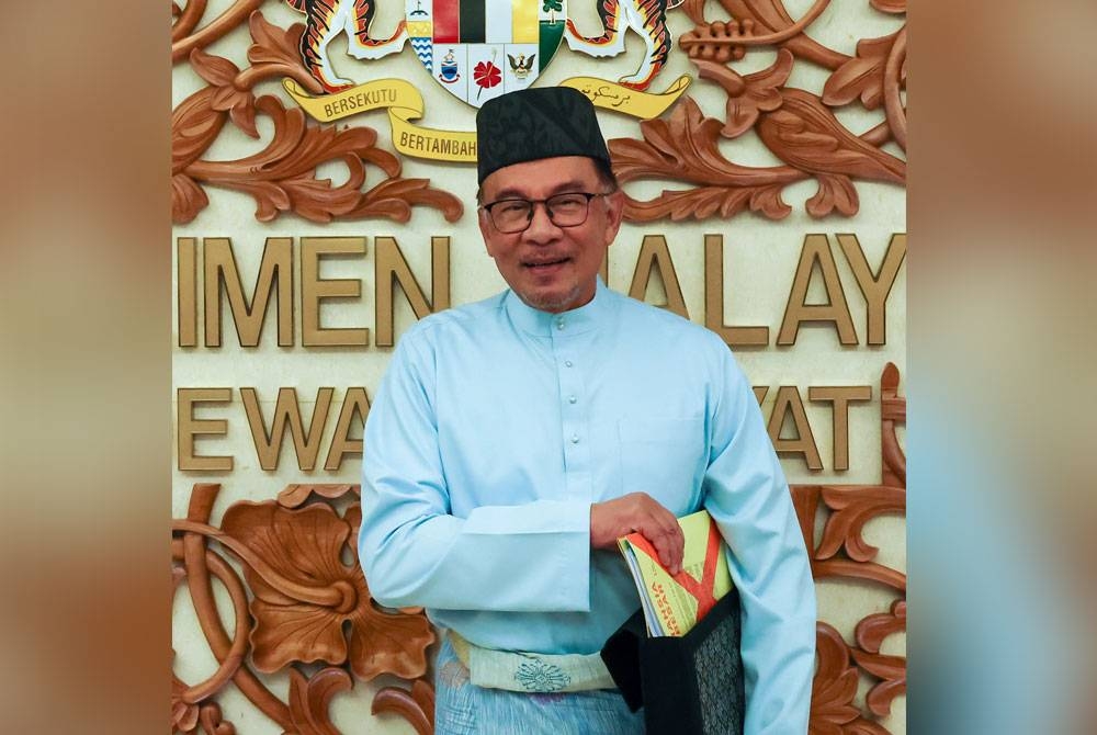 Anwar menunjukkan dokumen Belanjawan 2023 ketika tiba di Dewan Rakyat sebelum pembentangan Belanjawan 2023 Malaysia Madani di Parlimen pada Jumaat. - Foto Bernama