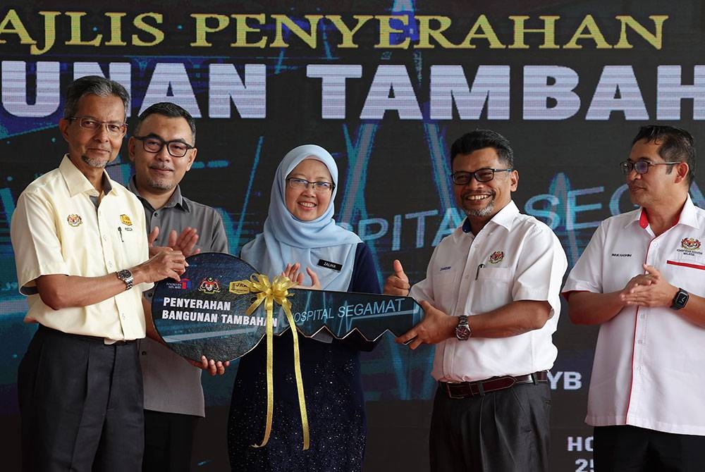 Dr Zaliha menyaksikan penyerahan replika kunci bangunan tambahan Hospital Segamat oleh Ketua Pengarah Kerja Raya, Datuk Ahmad Redza Ghulam Rasool (kiri) kepada Timbalan Ketua Setiausaha (Kewangan) Kementerian Kesihatan Malaysia, Datuk Zamzuri Abd Aziz pada Majlis Penyerahan Projek Bangunan Tambahan Hospital Segamat, Johor pada Sabtu. - Foto Bernama