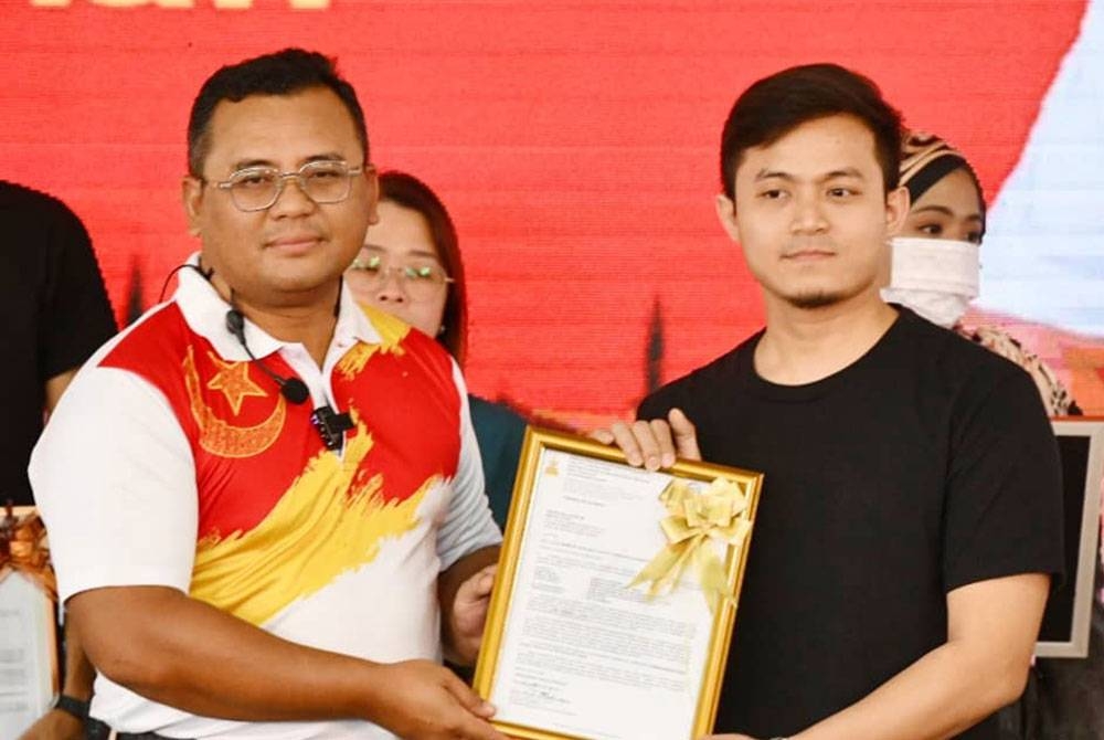 Amirudin (kiri) menyampaikan surat tawaran Rumah Selangorku kapada salah seorang penerima pada Jelajah Kita Selangor Penyayang di Taman Melawati di sini pada Sabtu.