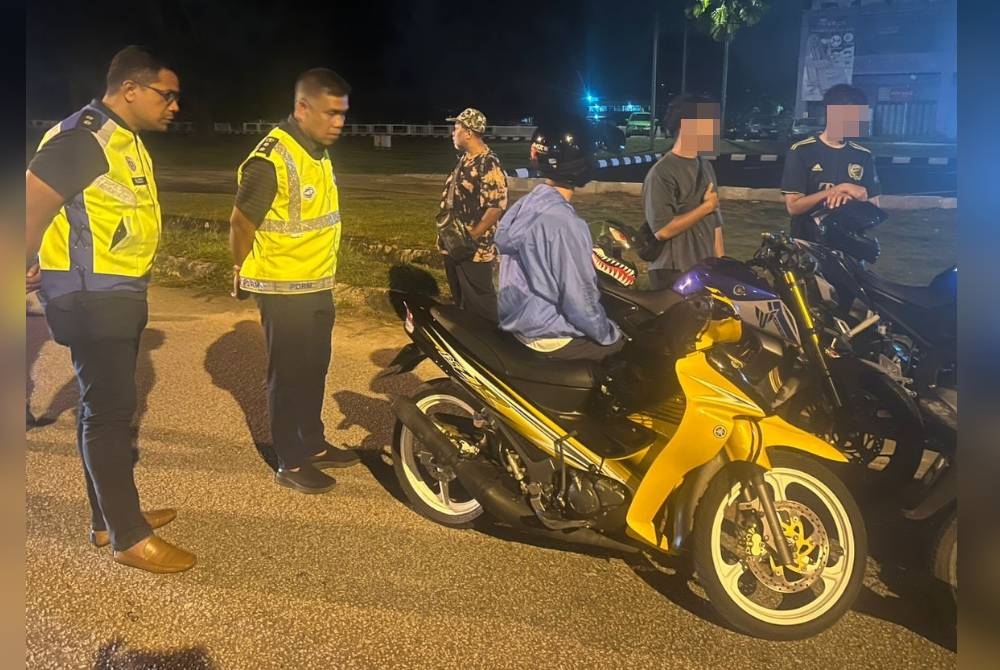 Wan Mohd Zahari (dua dari kiri) melakukan pemeriksaan ke atas penunggang yang ditahan dalam Ops Bersepadu Luaran Samseng Jalanan BSPT IPD Kuantan sekitar daerah ini pada Sabtu dan Ahad lalu.