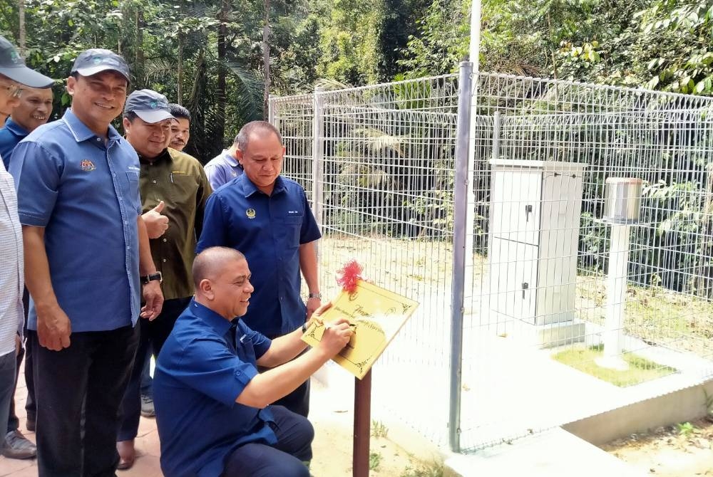 Saarani menurunkan tandatangan simbolik perasmian Sistem Amaran Awal Kepala Air di Taman Eko Rimba Kledang Saiong, Bandar Meru Raya di sini pada Isnin.