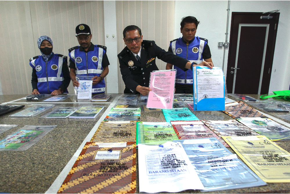 Ahmad Zaki (dua dari kanan) menunjukkan dokumen yang dirampas pihaknya di Pejabat Penguat Kuasa JHEAINS di Seremban pada Isnin.