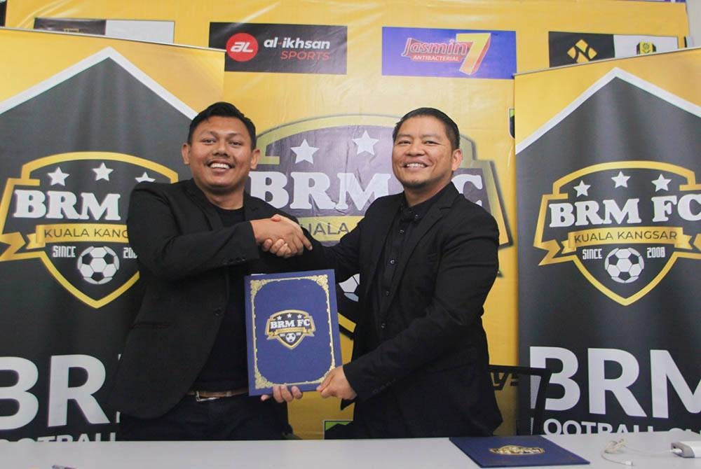 Ghafari (kiri) bersama Mohd Fauzi (kiri) dalam majlis Menandatangani Memorandum Persefahaman (MoU) antara Kuala Kangsar BRM FC dengan Raudhah Islamic School di sini pada Rabu.