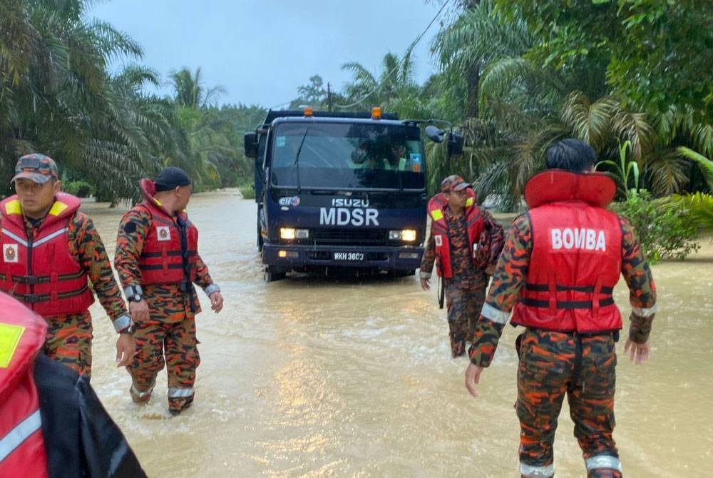 Anggota bomba membantu memindahkan mangsa banjir di Kampung Sri Rambai Machap, Simpang Renggam pada Rabu. - Foto bomba