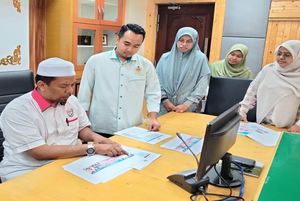 Wan Roslan (kanan) berbincang bersama urusetia Program Male Gegey Gegok Anok Mudo Kelate selepas sidang akhbar pada Rabu.