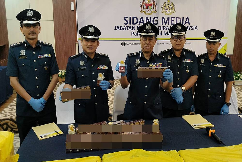 Wan Apandi (tengah) menunjukkan sebahagian rokok yang dirampas hasil penahanan sebuah lori di LPT1 dekat Gambang di sini pada 20 Februari lalu.