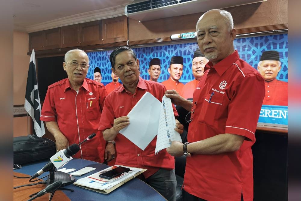 Mustapha (kanan) menunjukkan antara senarai calon dari UMNO Terengganu selepas menghadiri taklimat khas JPU Terengganu di Bangunan Badan Perhubungan UMNO Negeri Terengganu di Kuala Terengganu pada Rabu.