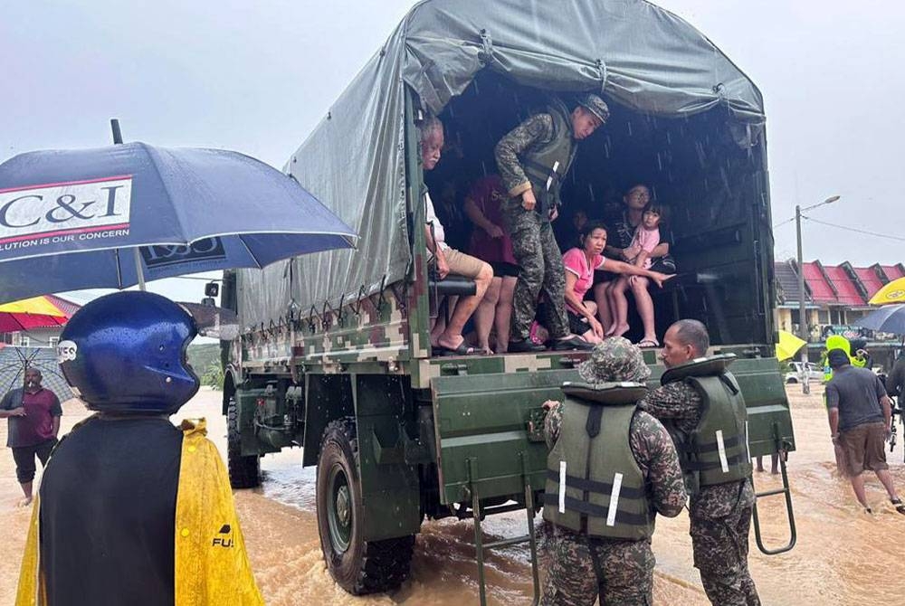 Anggota tentera membantu memindahkan mangsa banjir di sekitar Chaah, Segamat.