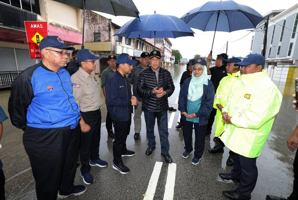 Ahmad Zahid (tengah) ketika melawat kawasan yang ditenggelami air akibat banjir di Bandar Kota Tinggi pada Khamis. - Foto Bernama