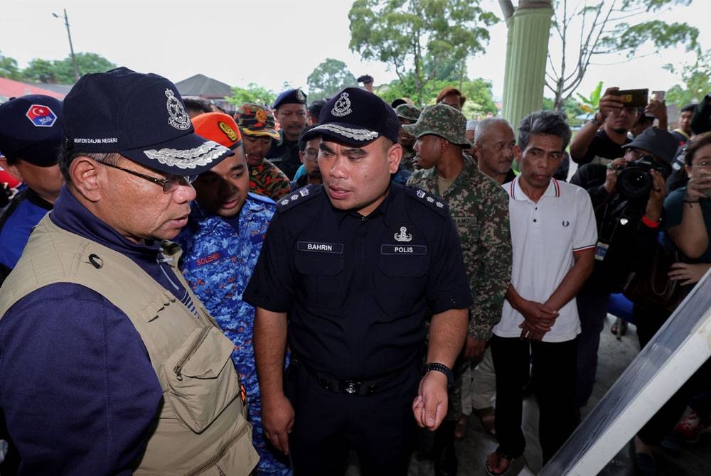 Saifuddin Nasution (kiri) mendengar penerangan dari Ketua Polis Daerah Kluang, Asisten Komisioner Bahrin Mohd Noh (dua dari kiri) pada lawatan di Pusat Pemindahan Sementara (PPS) Dewan Orang Ramai Kampung Melayu pada Jumaat. - Foto: Bernama