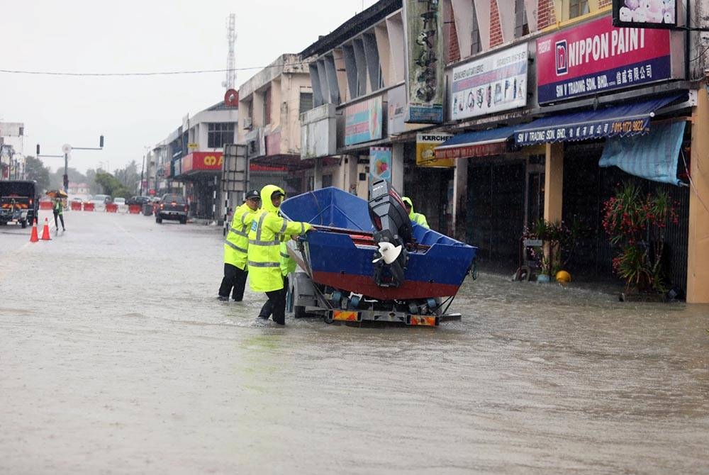 Anggota polis melakukan pemantauan di bandar Kota Tinggi pada Sabtu yang terjejas teruk akibat banjir.