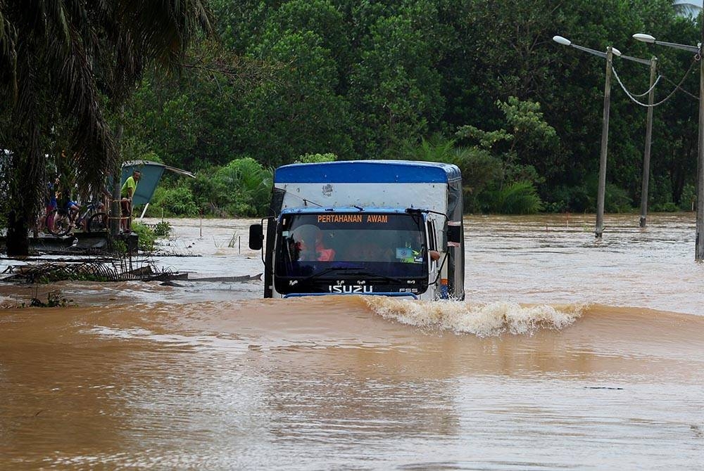 Sebuah lori APM meredah air banjir yang membawa barangan keperluan asas bagi mangsa banjir di Lenga, Muar pada Sabtu.- Foto: Bernama