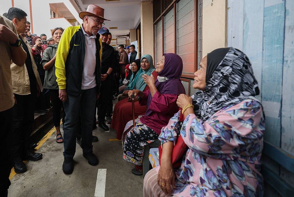  Perdana Menteri Datuk Seri Anwar Ibrahim meluangkan masa meninjau dan melawat mangsa banjir di Pusat Pemindahan Sementara (PPS) Sekolah Kebangsaan Gemereh hari ini. - Foto Bernama