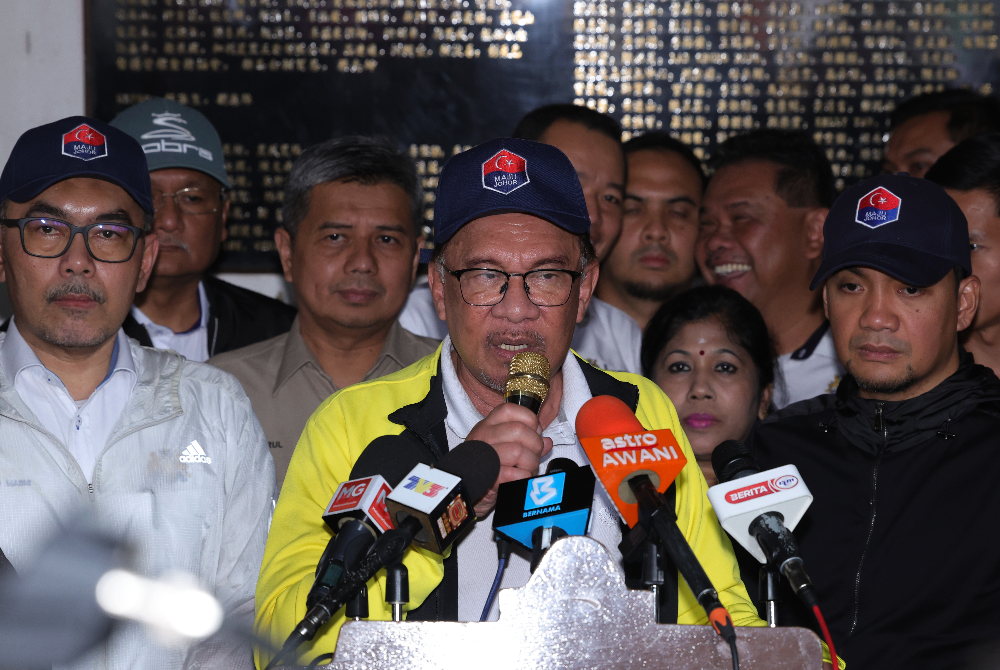 Anwar (tengah) ketika sidang akhbar selepas melawat mangsa banjir di PPS Sekolah Jenis Kebangsaan (Cina) Kampung Tengah pada Ahad. - Foto Bernama