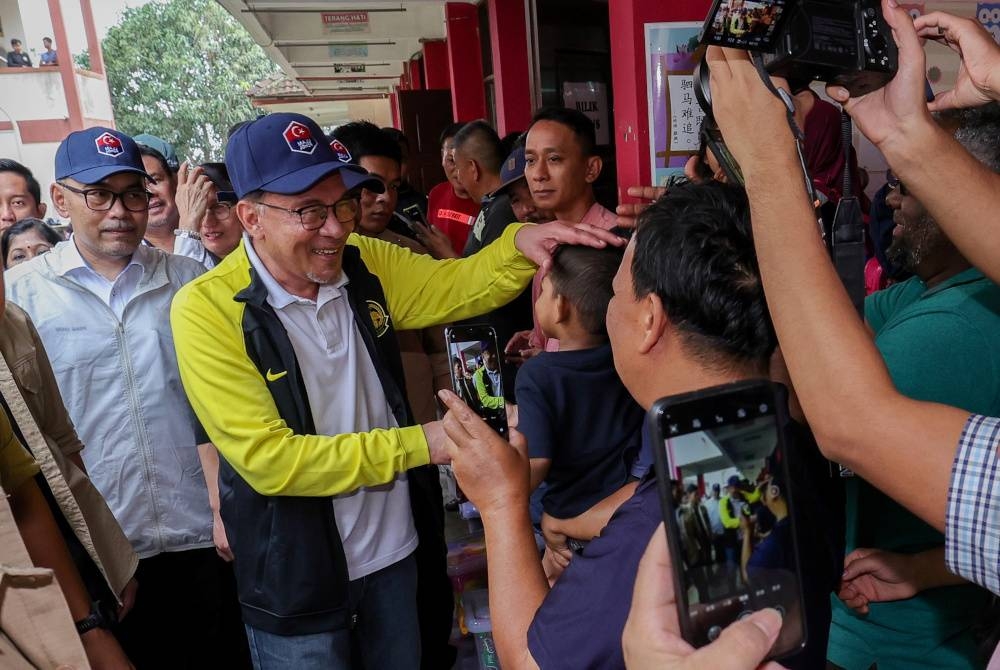 Anwar ketika hadir bagi melawat mangsa banjir di PPS SJKC Kampung Tengah. - Foto Bernama