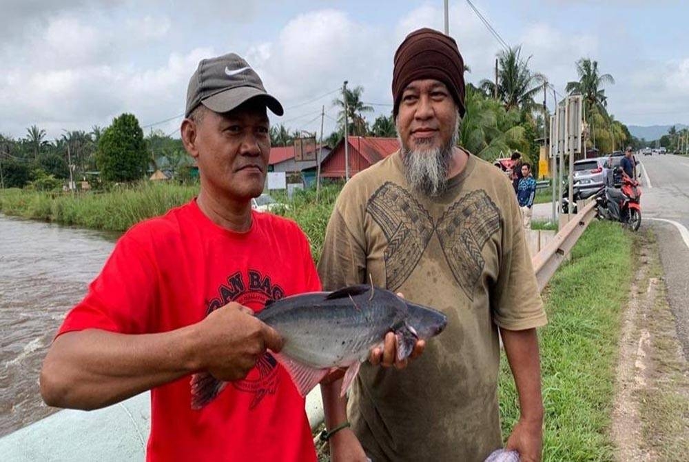 Penduduk di Parit Yaani menyumbangkan hasil menjala ikan kepada mangsa yang dipindahkan ke PPS. - Foto Bernama