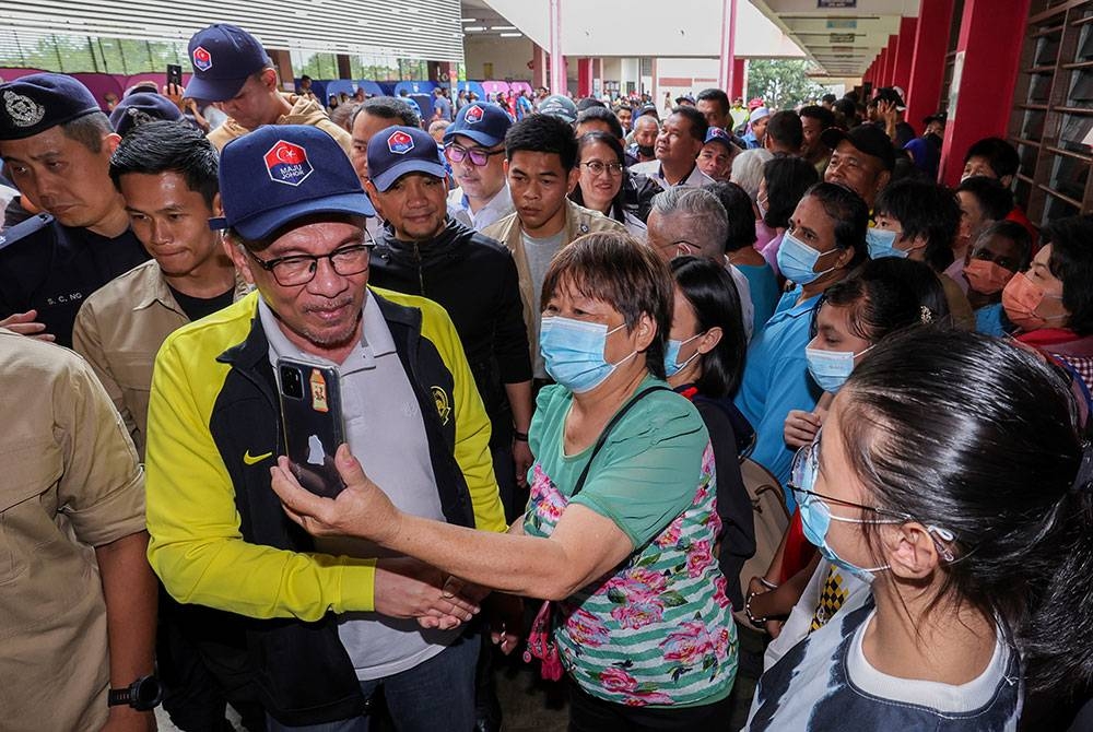 Anwar ketika hadir bagi melawat mangsa banjir di PPS Sekolah Jenis Kebangsaan (Cina) Kampung Tengah pada Ahad. - Foto Bernama