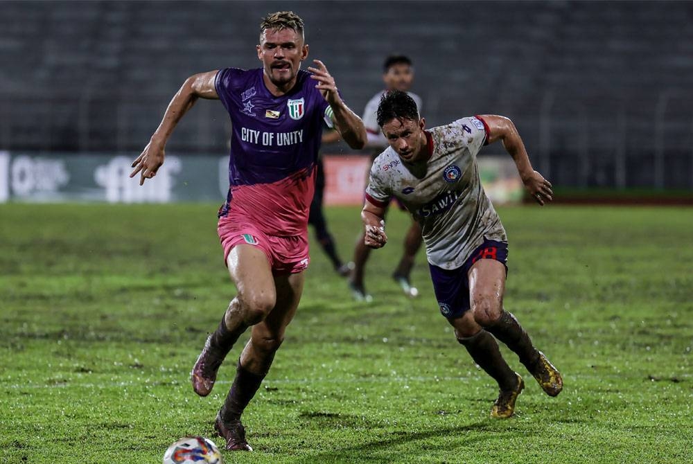 Pemain pertahanan Kuching City FC , Aylton Ferreira (kiri) dikejar oleh penyerang Sabah FC, Darren Yee pada perlawanan saingan Liga Super di Stadium Negeri, malam ini. - Foto Bernama