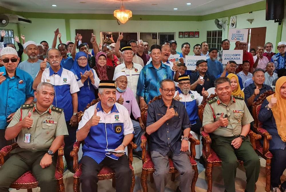 Abdul Rahman (duduk tengah) dan Mohd Akram (dua dari kiri) bersama warga Koperasi Veteran Rejimen Semboyan Diraja dan Angkasa yang hadir program di Jalan Padang Tembak pada Selasa.