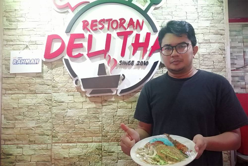 Mohd Fadli menunjukkan nasi kerabu ikan yang ditawarkan demgan harga RM5 termasuk minuman.