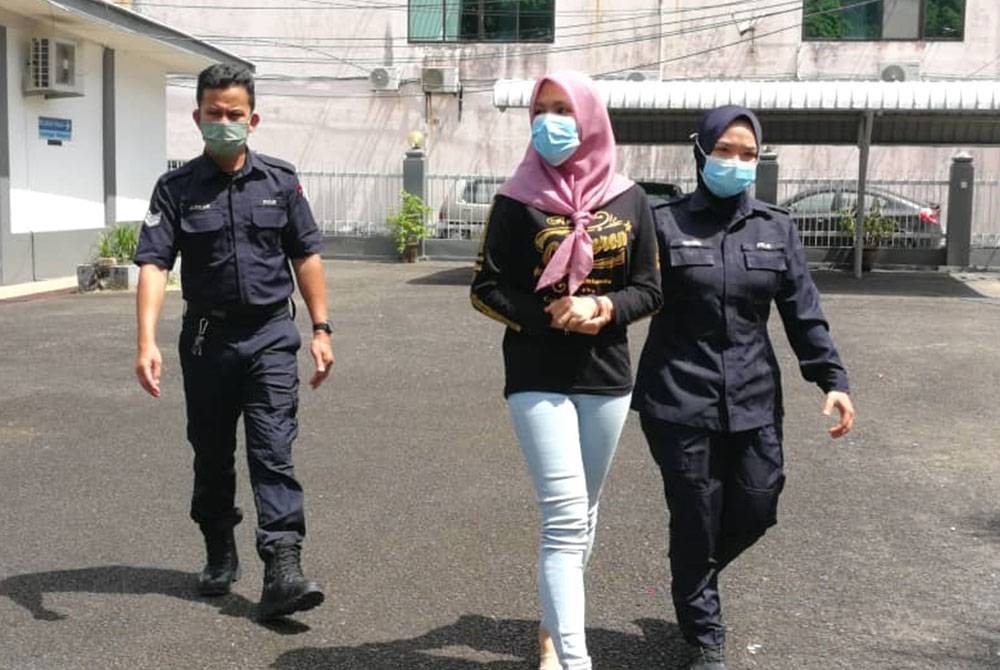 Tertuduh (tengah) ketika dihadapkan di Mahkamah Majistret Kemaman pada Rabu.