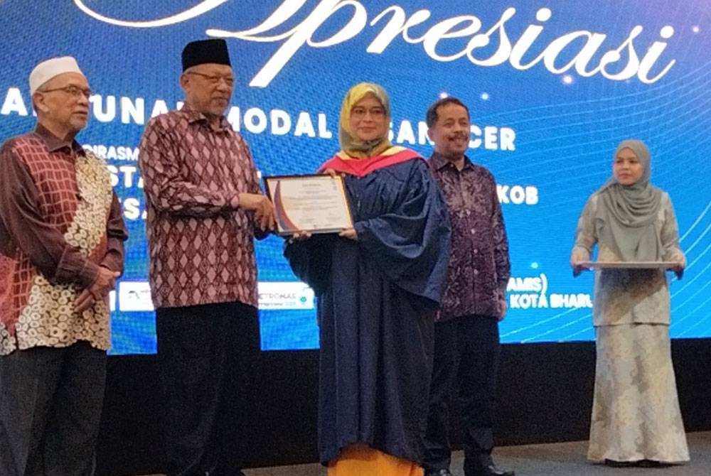 Ahmad (dua dari kiri) menyampaikan sijil kepada peserta program ECERDC sempena Program Pembangunan Modal Insan ECERDC pada Khamis.