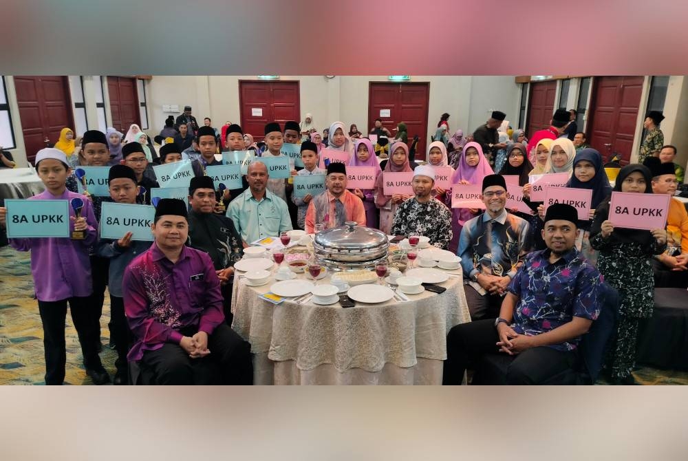 Sebahagian pelajar cemerlang UPKK 2022 negeri Pahang yang memperoleh keputusan 8A bergambar bersama Dr Zulkifle (duduk, tengah) selepas Majlis Pengumuman Keputusan UPKK Negeri Pahang di sebuah hotel di Kuantan pada Khamis.