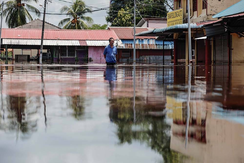 Keadaan di pekan Parit Sulong yang masih digenangi banjir termenung. - Foto: Bernama