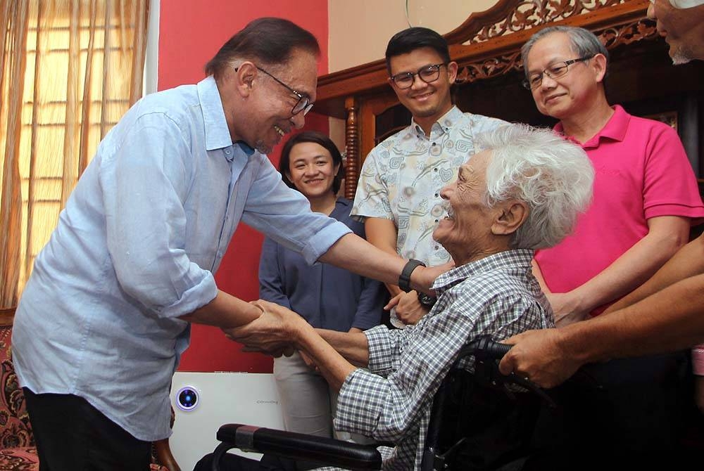 Anwar (kiri) meluangkan masa menziarahi Ahmad Fawzi Shafii, 75, yang merupakan rakan sekolahnya semasa menuntut di MCKK di Desa Seri Ampang, Ipoh pada Sabtu. - Foto: Bernama