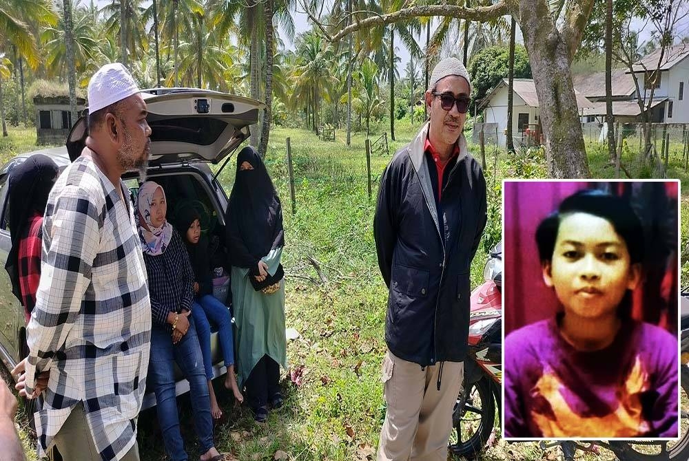 Kamarul Bahri (kanan) menunggu perkembangan pencarian anaknya yang dikhuatiri lemas di Pantai Cempaka di sini. (Gambar dalam :Nasrul Aimi Shah)