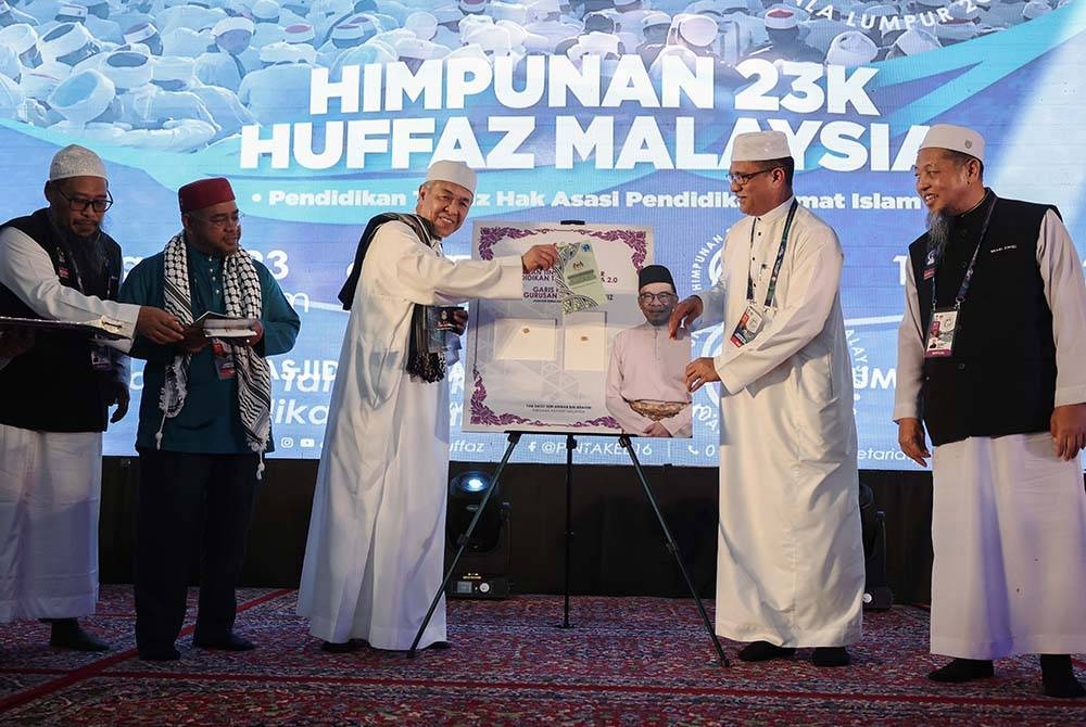 Ahmad Zahid (tiga dari kiri) menyempurnakan pelancaran Pelan Tindakan Dasar Pendidikan Tahfiz Negara 2.0 dan Garis Panduan Pengurusan Institusi Tahfiz pada Majlis Himpunan 23K Huffaz Malaysia di Majlis Wilayah Persekutuan pada Sabtu. - Foto Bernama