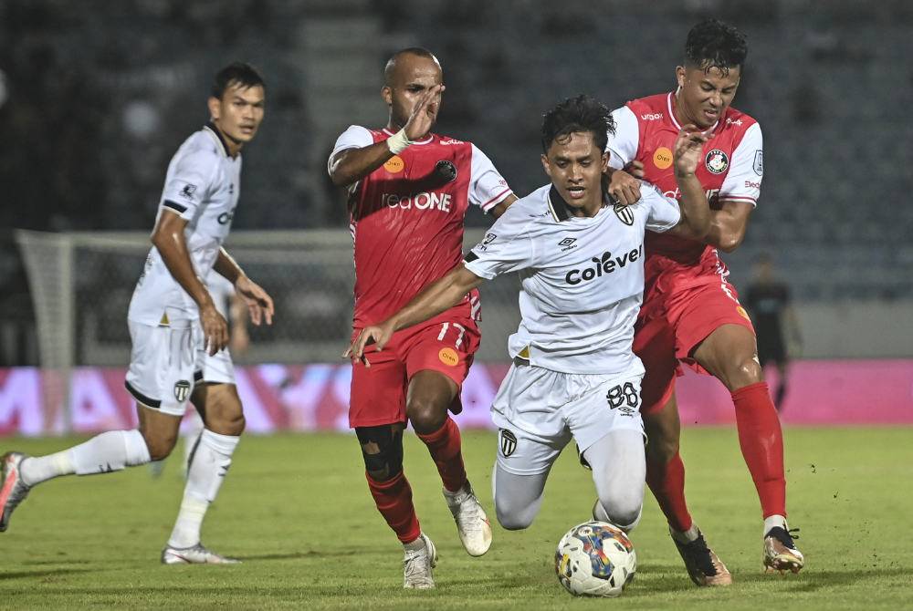 Pemain TFC, Nik Muhammad Sharif Haseefy Mohd Lazim (dua, kanan) diasak dua pemain PDRM pada perlawanan Liga Super di Stadium Sultan Mizan Zainal Abidin pada Sabtu.