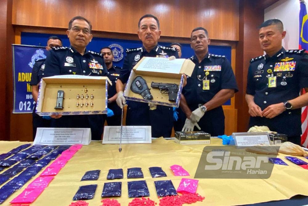 Muhamad Zaki (dua dari kiri) menunjukkan pistol dan dadah yang dirampas daripada seorang penternak lembu di Taman Desa Rahmat, Guchil, Kota Bharu.