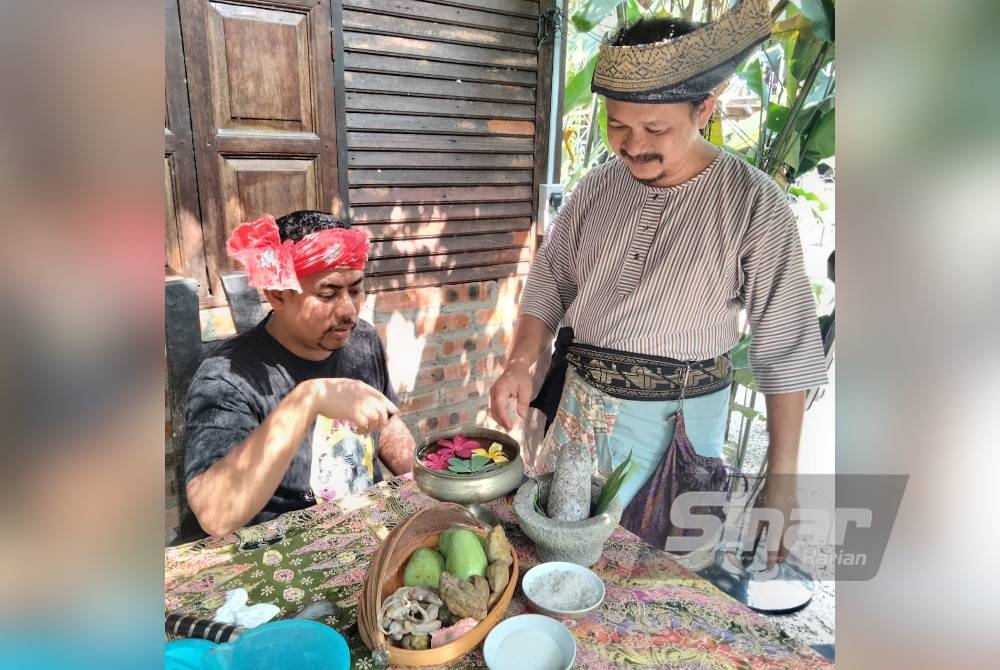 Mohamad (kanan) menerangkan buah yang boleh dimakan bersama colek kepada peminat colek di Singgora.