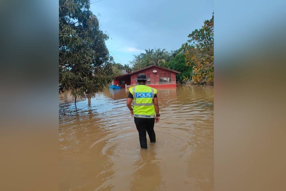 Anggota polis memantau kawasan sekitar di Yong Peng yang dilanda banjir. - Foto APM Batu Pahat